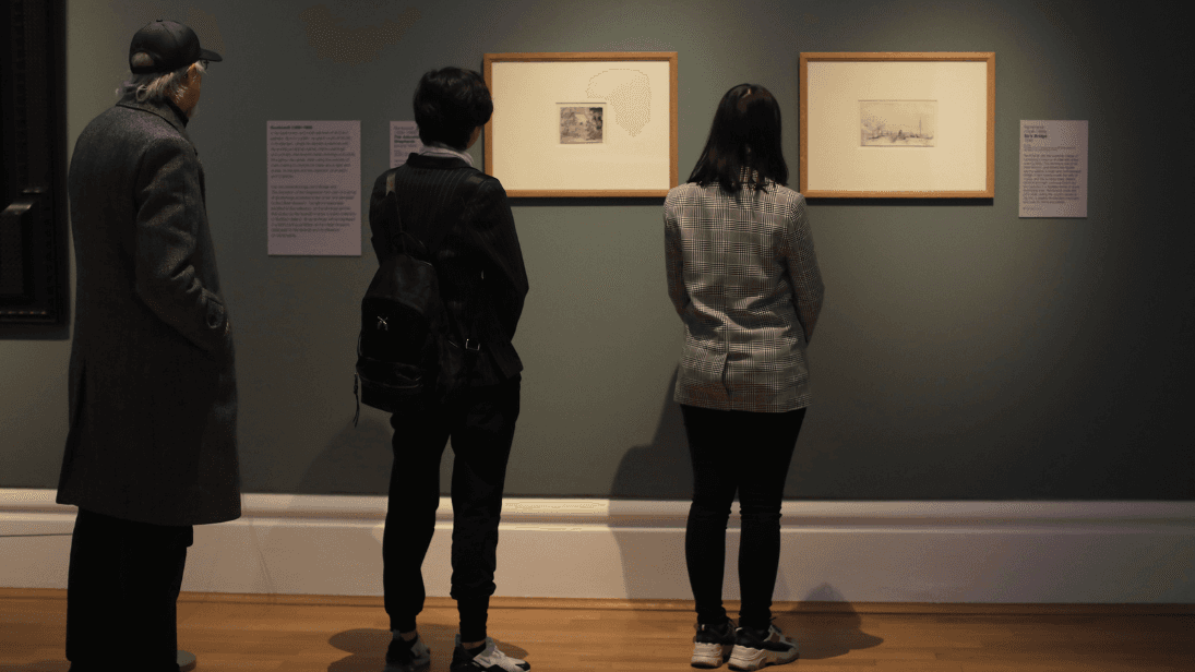 3 people looking at Rembrandts etchings